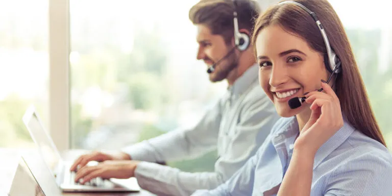 Hospitality support agents in headsets working at laptops