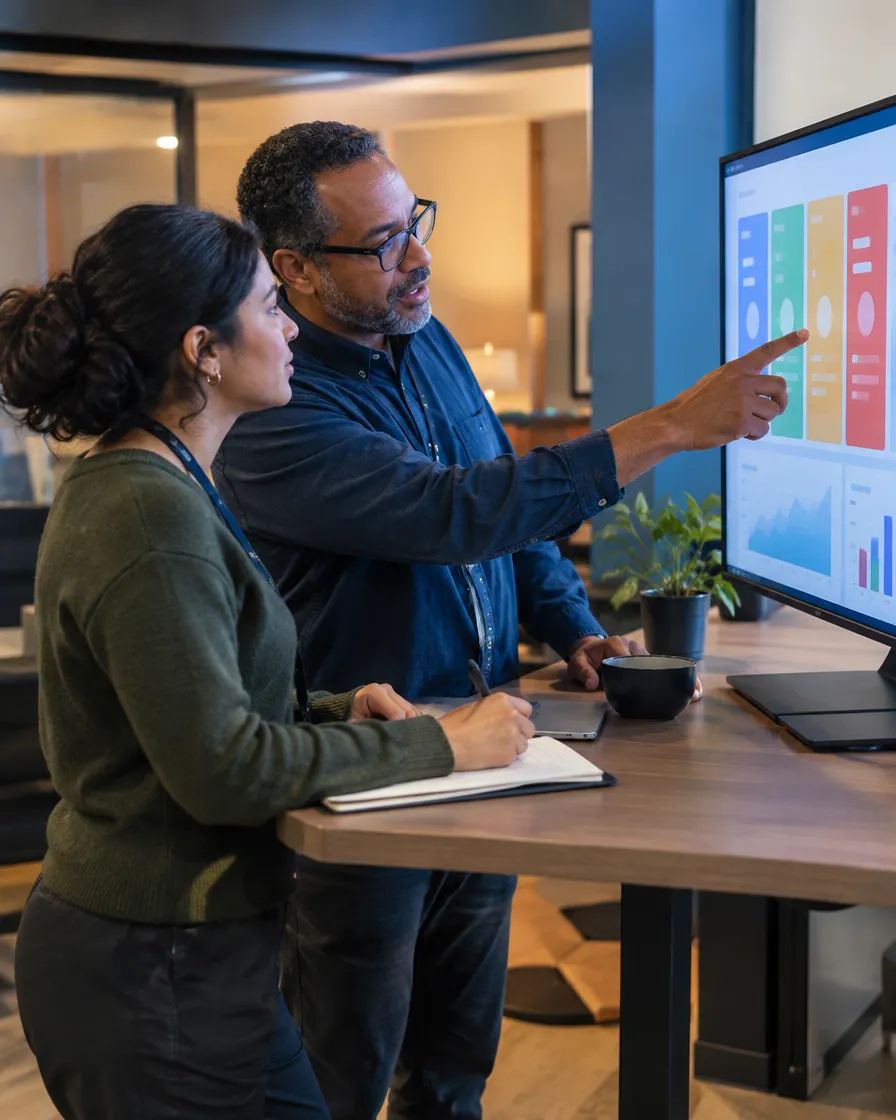 Two MVNO specialists reviewing a porting workflow on a monitor